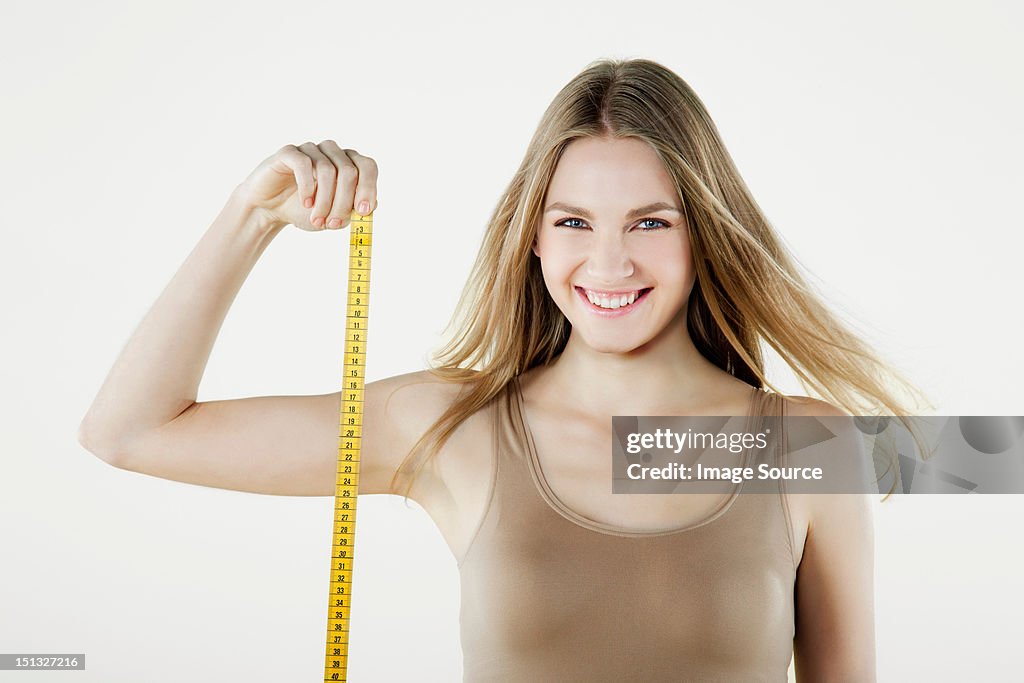 Young woman holding tape measure