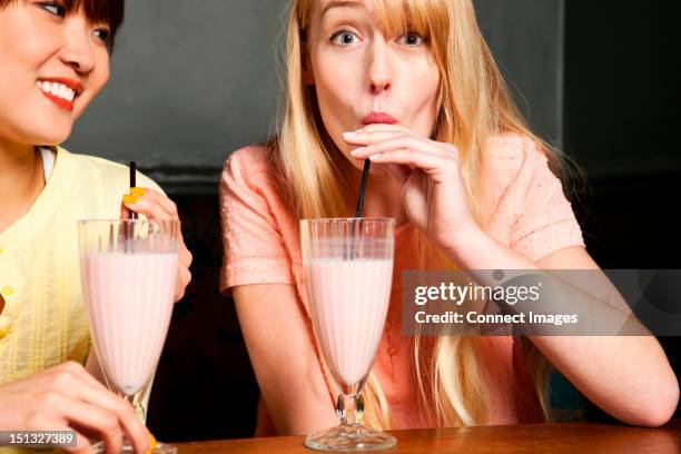 two women drinking milkshake - milkshake stock pictures, royalty-free photos & images