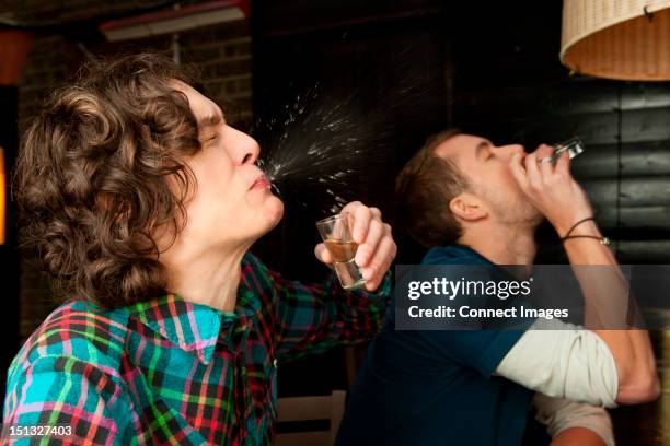 two men drinking shots - spitting stock pictures, royalty-free photos & images