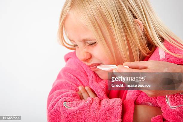 parent trying to give daughter medicine, girl refusing - taste for a cure stock pictures, royalty-free photos & images