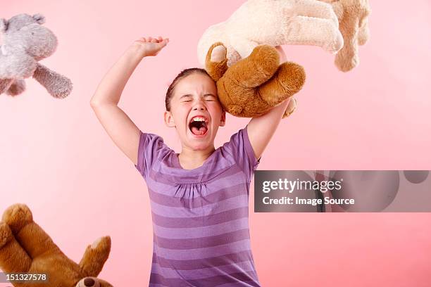 girl throwing teddy bears - woedeaanval stockfoto's en -beelden