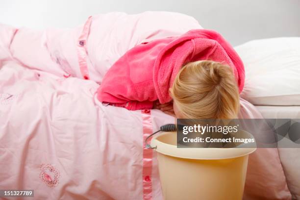 sick girl with bucket - vomitare foto e immagini stock