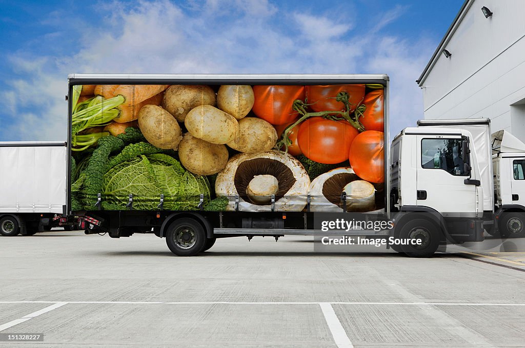 Truck with vegetables parked outside distribution warehouse