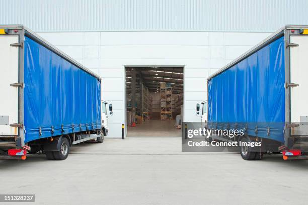 trucks parked outside distribution warehouse - symmetry stock pictures, royalty-free photos & images