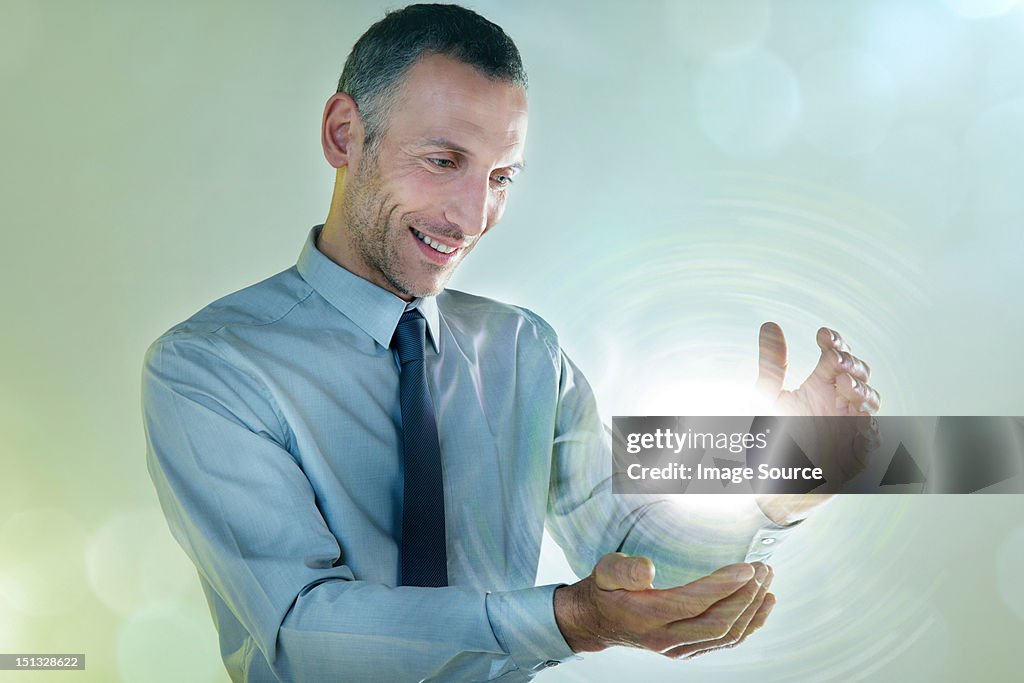 Businessman holding ball of light