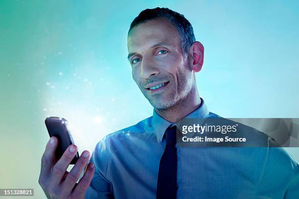 businessman holding cellphone with lights - smartphone hologram stock-fotos und bilder