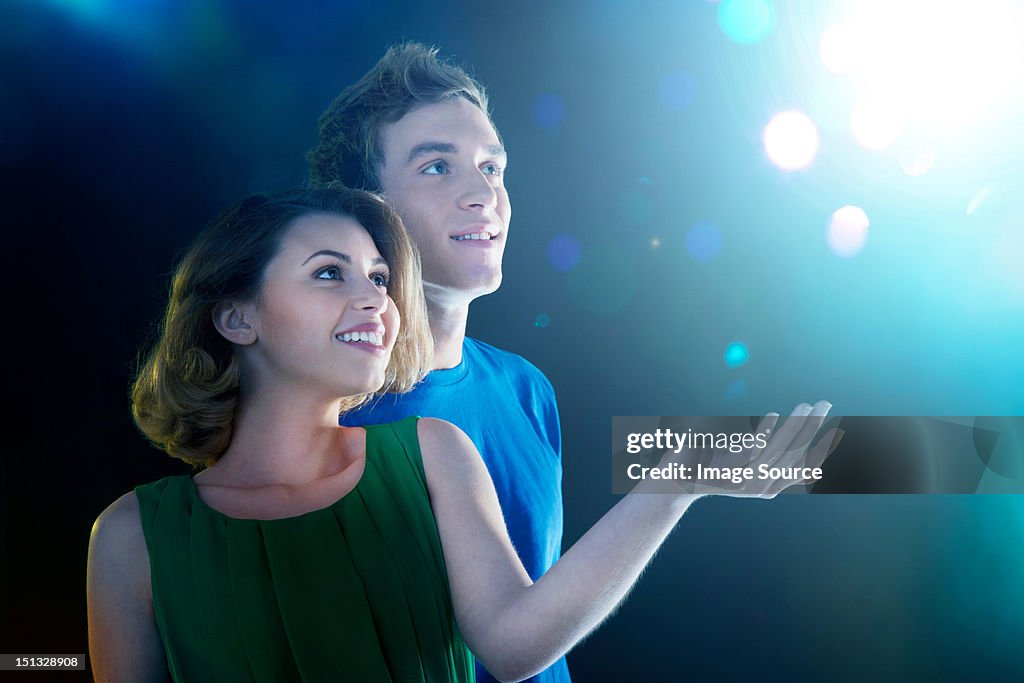 Young couple looking up at light