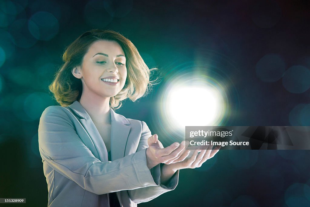 Young woman holding ball of light