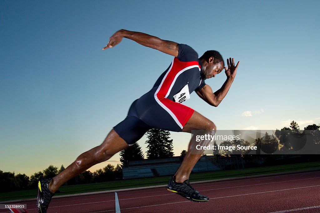 Male athlete leaving starting blocks