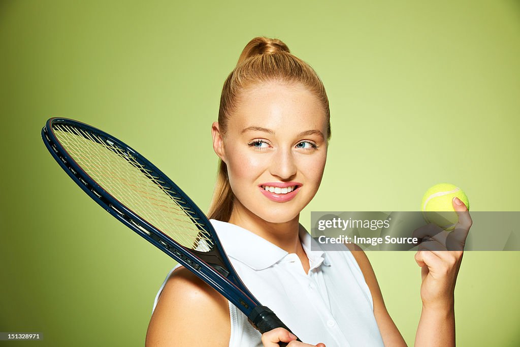 Young woman with tennis racket and tennis ball