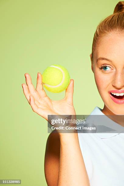 young woman holding tennis ball - tennis ball hand stock pictures, royalty-free photos & images