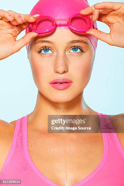 female swimmer with pink goggles and cap - studio portrait swimmer photos et images de collection