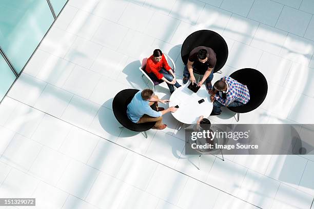 overhead view of colleagues in meeting - atrio fotografías e imágenes de stock