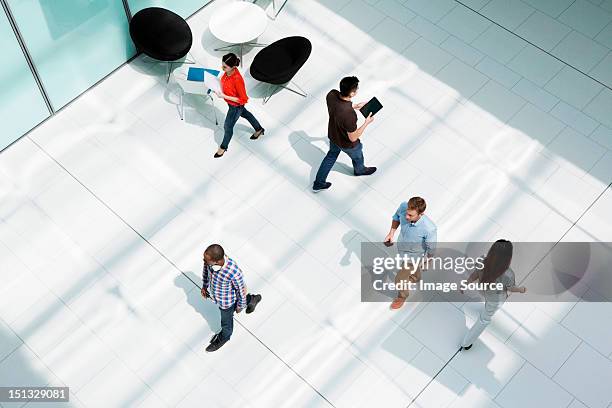 people walking on office concourse - office elevated view stock pictures, royalty-free photos & images