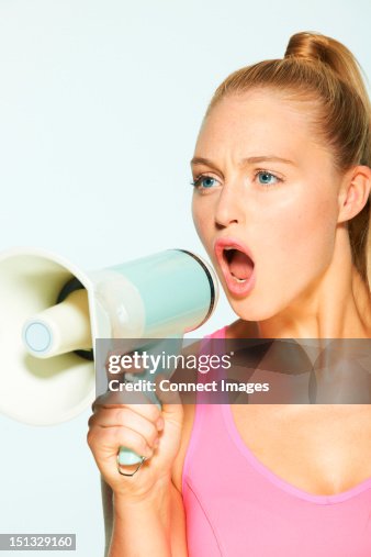 Young woman shouting through megaphone Young woman shouting through megaphone