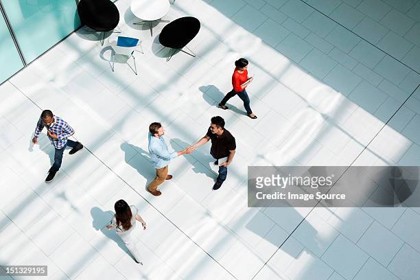 men shaking hands on concourse - welcoming stock pictures, royalty-free photos & images
