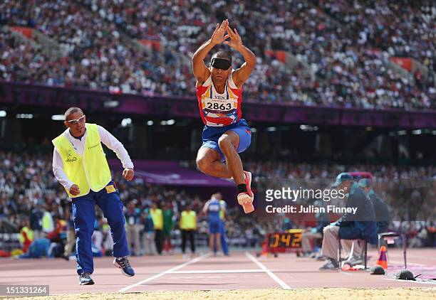 Oscar David Herrera of Venezuela is assisted by his guide as he competes in the Men's Triple Jump - F11 Final on day 8 of the London 2012 Paralympic...