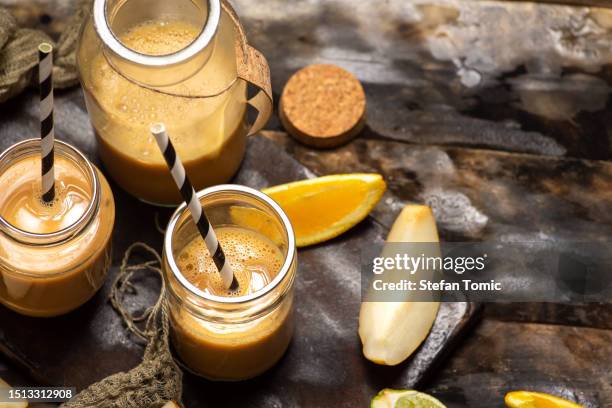 smoothies in a jar pear, orange and banana - yoghurt lid stock pictures, royalty-free photos & images