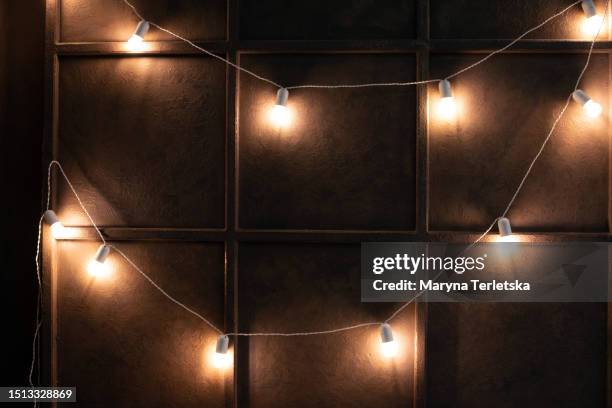 garland of light bulbs on the wall. festive universal background. - broken light bulb stock pictures, royalty-free photos & images