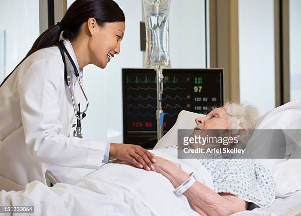 doctor comforting patient in hospital - namensband stock-fotos und bilder
