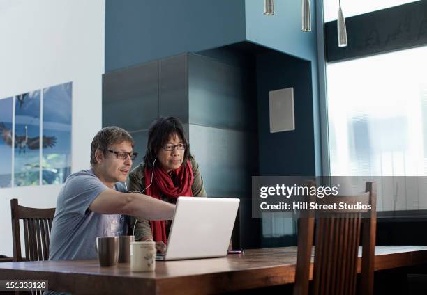 couple using laptop together - couple 50 55 laptop stock-fotos und bilder