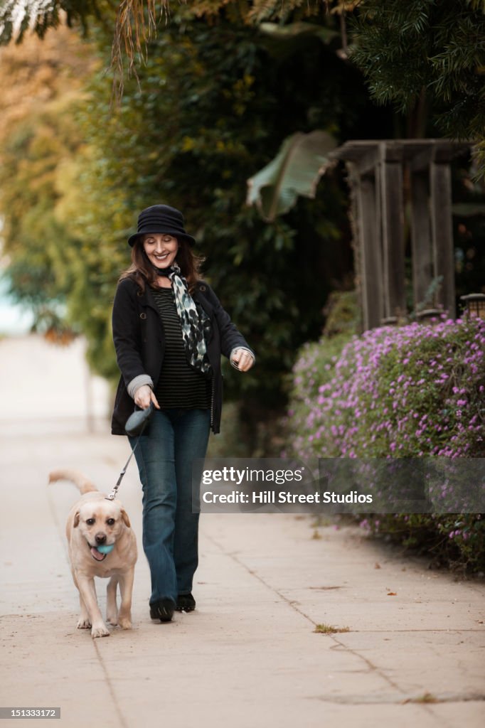 Caucasian woman walking dog