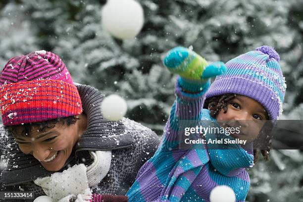 black mother and daughter having a snowball fight - snowball stock pictures, royalty-free photos & images