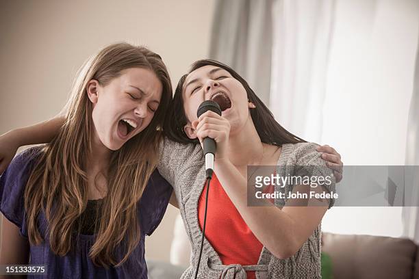 friends singing karaoke together - holding microphone stock pictures, royalty-free photos & images