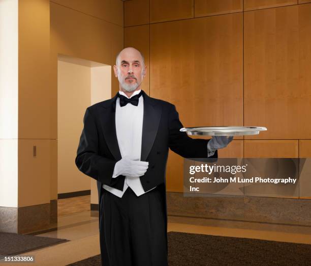 serious butler holding tray - waiter stock pictures, royalty-free photos & images