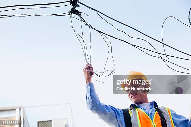 cable lineman on ladder fixing dangling wires - cable installer stockfoto's en -beelden