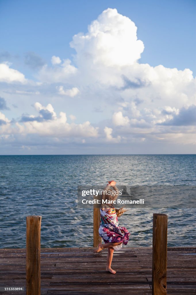 Caucasian girl dancing on pier