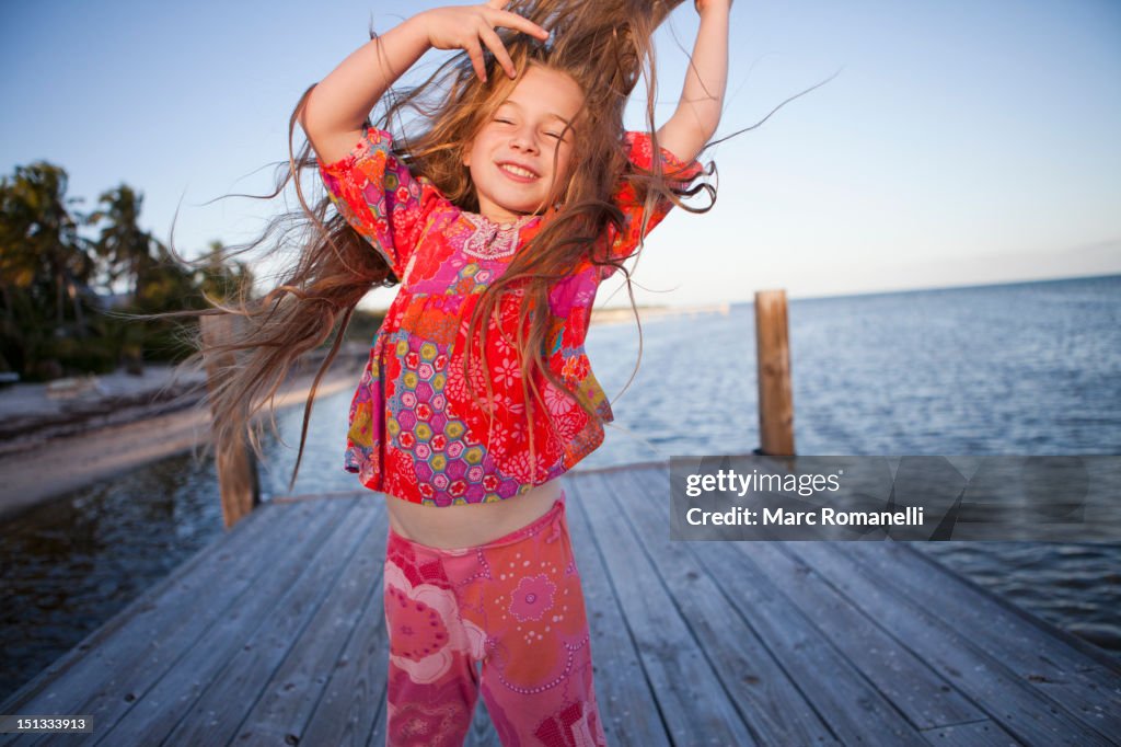 Caucasian girl dancing on pier
