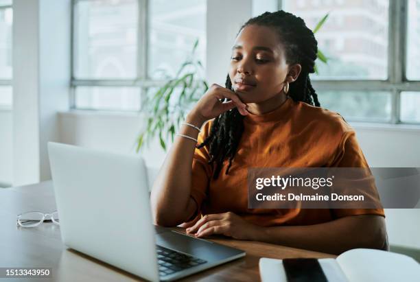 eine junge schwarze geschäftsfrau, die an ihrem laptop arbeitet - artikel publikation stock-fotos und bilder