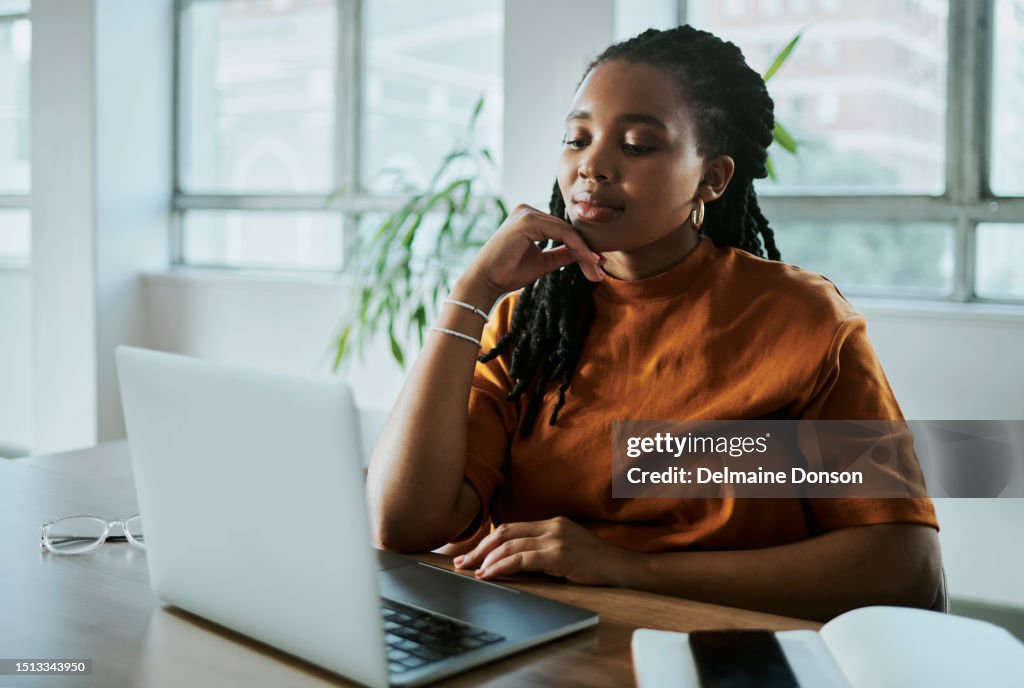 Uma jovem empresária negra trabalhando em seu laptop