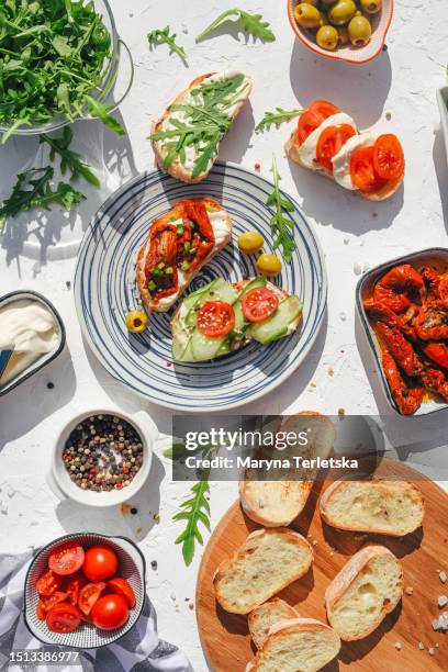 a variety of healthy toasts with vegetables, seeds and microgreens. colorful, plant-based vegan snacks. stylish table setting and food. catering. food delivery. festive table. - grundnahrungsmittel stock-fotos und bilder