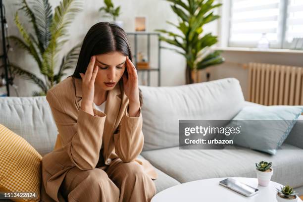 stressed young woman having a headache - trigger stock pictures, royalty-free photos & images