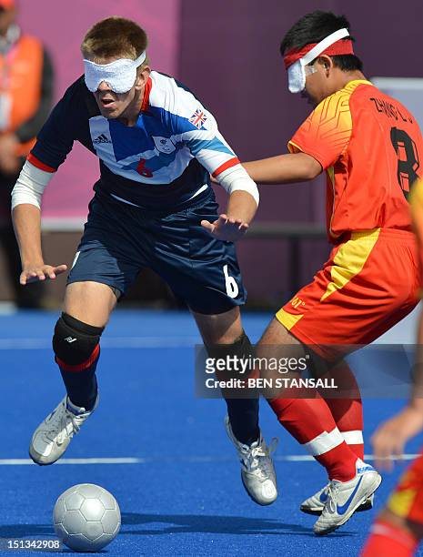 Britain's Robin Williams vies for the ball with China's Zhang Lijing in the 5-a-side 5-8 semi-final football match between Britain and China during...