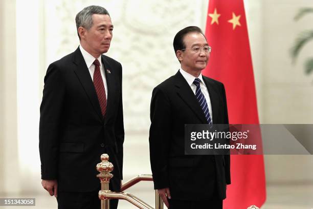 Chinese Premier Wen Jiabao and Singapore Prime Minister Lee Hsien Loong listen to their national anthems during a welcoming ceremony at the Great...