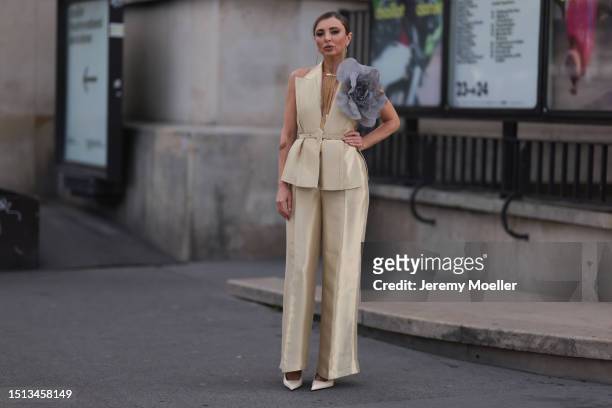 Svitlana Degtyarenko seen outside Georges Hobeika show wearing long golden earrings, golden shiny Fendi suit with a logo Fendi belt combined with a...