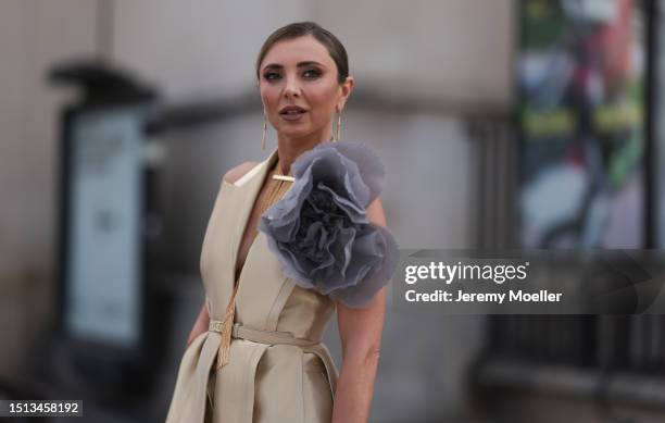 Svitlana Degtyarenko seen outside Georges Hobeika show wearing long golden earrings, golden shiny Fendi suit with a logo Fendi belt combined with a...