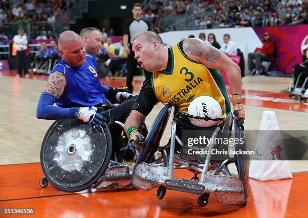 Ryley Batt of Australia and Per-Johan Uhlmann of Sweden battle for the ball during a Paralympic Wheelchair Rugby match on day 8 of the London 2012...