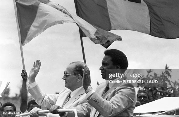 French President François Mitterrand and Rwandan President Juvenal Habyarimana wave to a crowd 07 October 1982 as they tour Kigali after Mitterrand's...