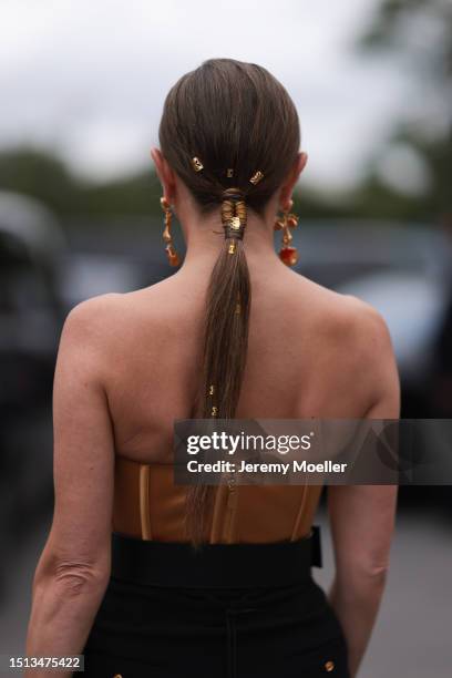 Svitlana Degtyarenko seen outside Schiaparelli show wearing golden Schiaparelli earrings, Schiaparelli bustier in golden fabric, big Schiaparelli...