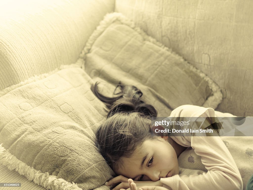 Girl unwell rests on sofa