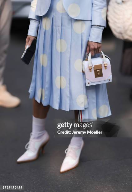 Tina Leung is seen wearing sunglasses in butterfly shape with a big white frame, a matching outfit from Thom Browne in light blue with big white...