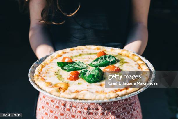 pizza margherita in woman's hands close-up. - cheese pizza stock pictures, royalty-free photos & images
