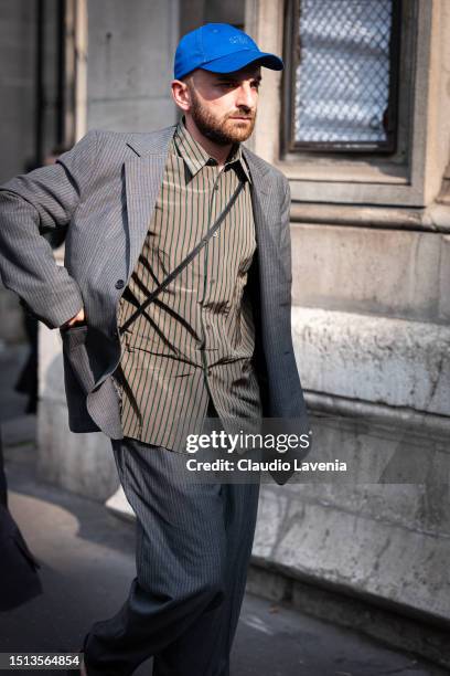 Beka Gvishiani wears a grey striped suit, brown striped shirt and blue hat, outside Thom Browne, during the Haute Couture Fall/Winter 2023/2024 as...