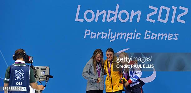 Australia's gold medallist Jacqueline Freney poses on the podium flanked by US silver medallist Cortney Jordan and Britain's bronze medallist...