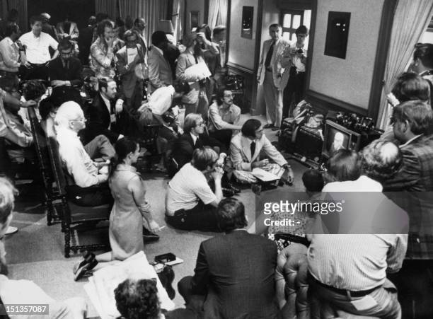 Journalists look at television in White House press room while President Richard Nixon announces his resignation, 08 August 1974. A burglary inside...