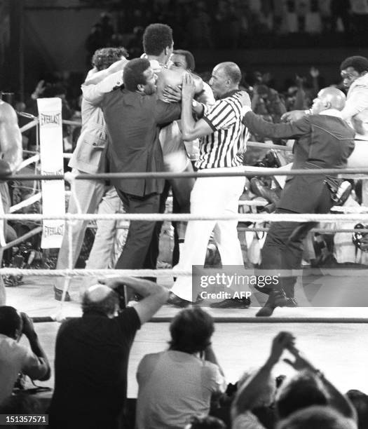 Son équipe ainsi que l'arbitre du match entourent le boxeur Mohamed Ali qui vient de remporter le titre de champion du monde de boxe des poids...